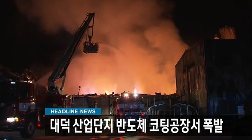 야간 산업단지 화재 현장. 소방 고가차가 화점을 향해 방수하고 있다.